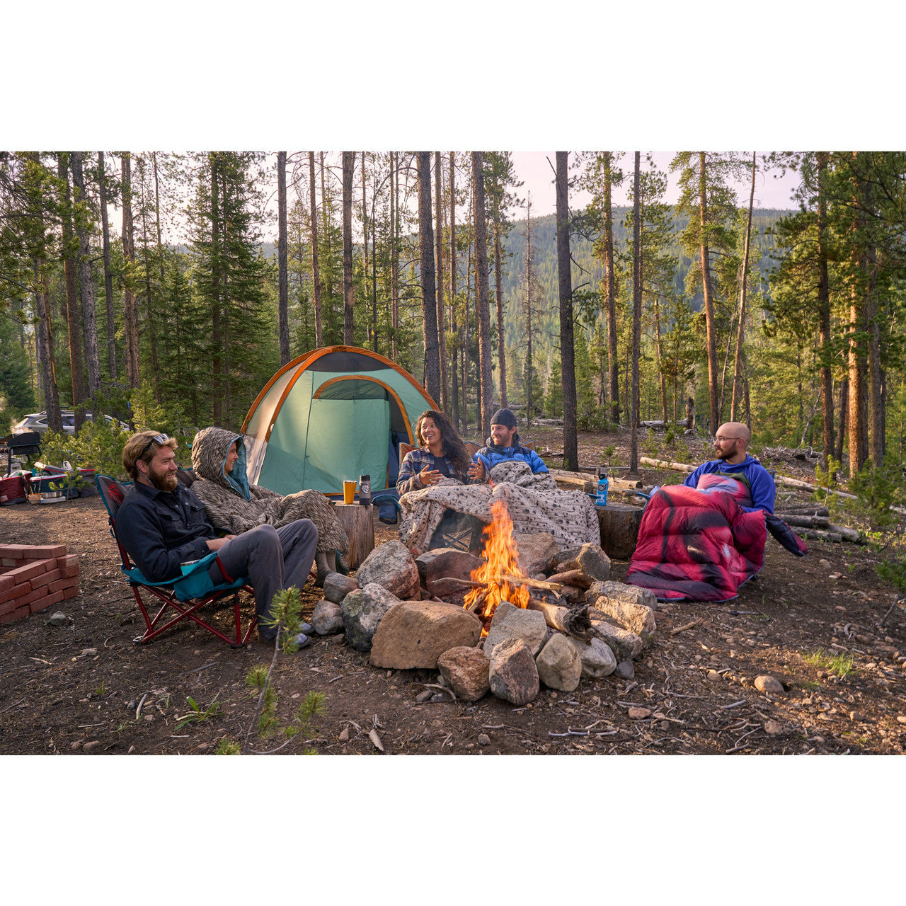 Group of campers with Biggie Blanket around campfire