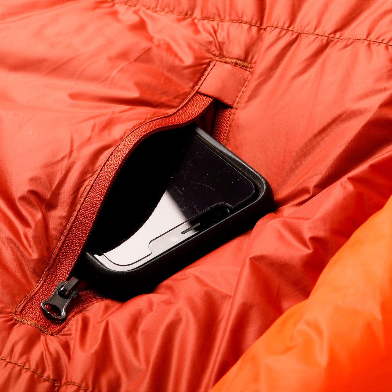 Close up of Kelty Cosmic Ultra 0 sleeping bag, showing phone in storage pocket