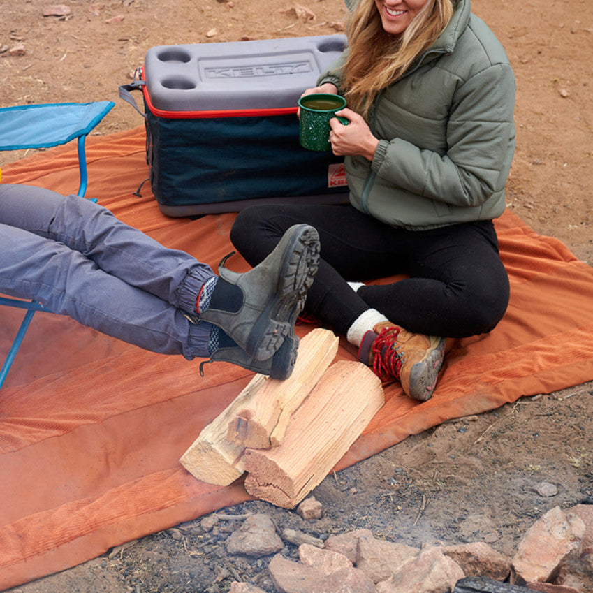 Two women sitting on the Kelty Cordavan Blanket