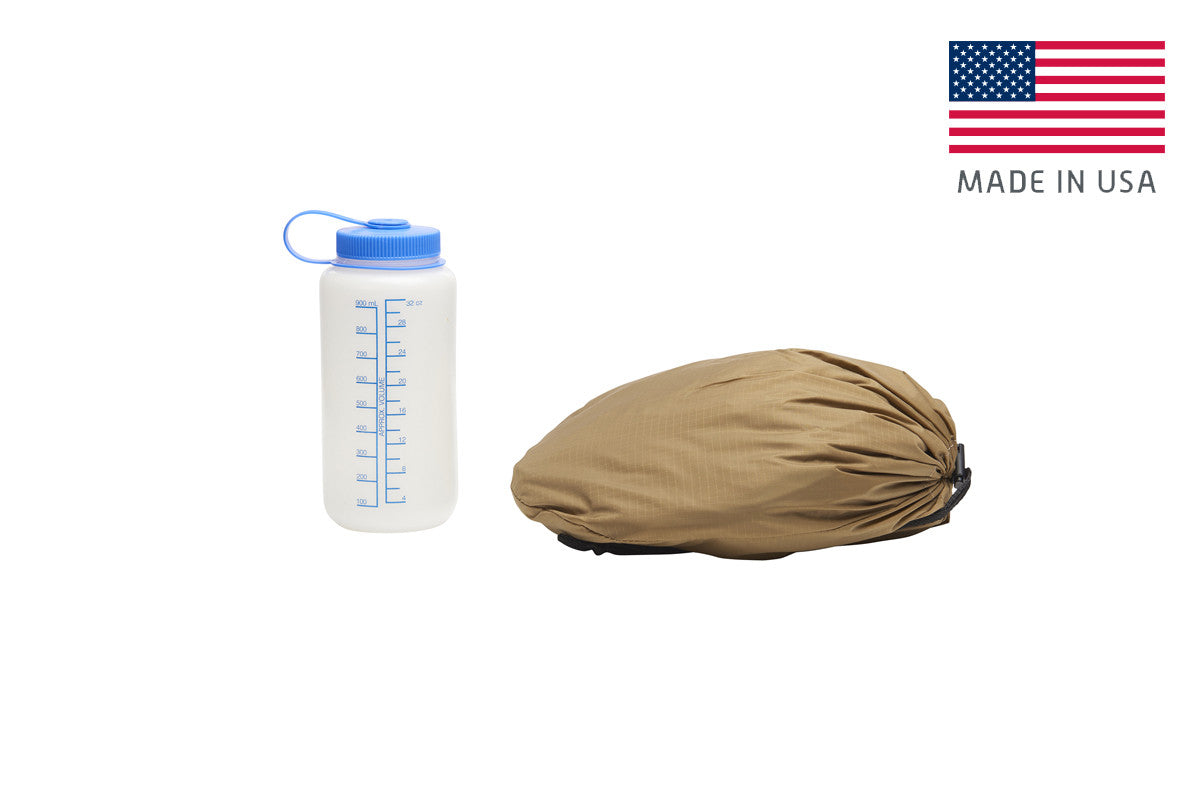 Kelty VariCom No Fly Zone USA bivy, shown packed inside of storage bag, bag lying flat next to 32 oz. water bottle