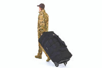 Man pulling Kelty BRT USA rolling trunk on its wheels